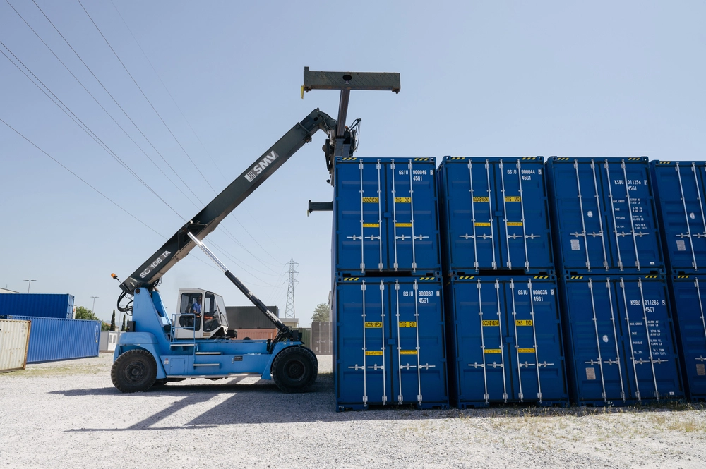 Reach stacker SMV Perullo movimenta container blu impilati